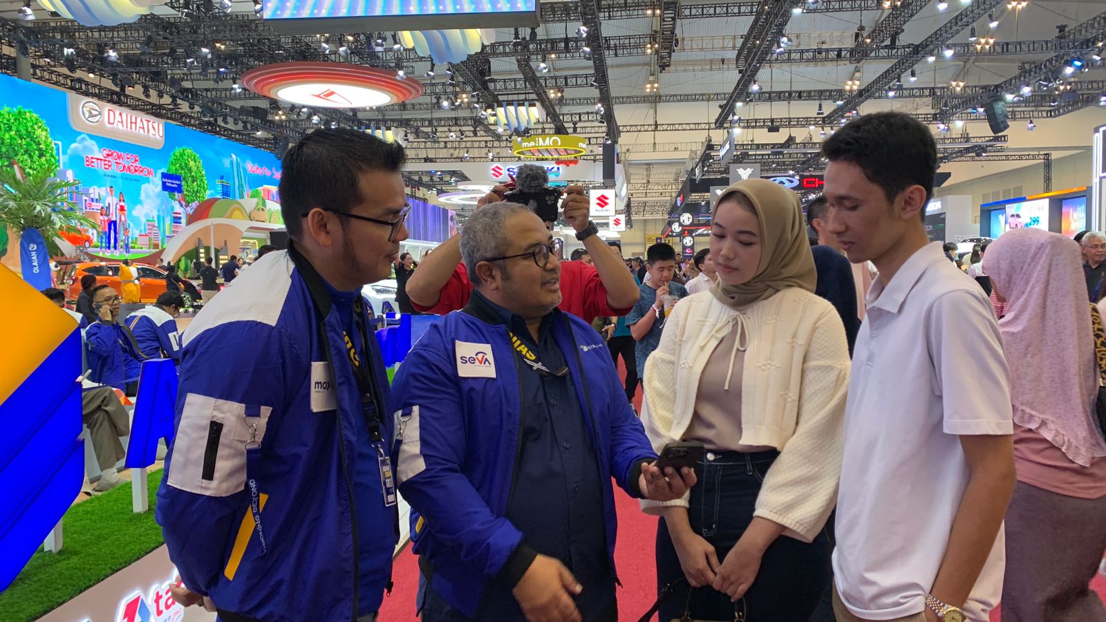 Chief Marketing & Growth SEVA, Dadi Hendriadi (kedua dari kiri) dan Marketing Division Head, David Thamrin (kiri) menjelaskan fitur unggulan dan program “Hajatan SEVA di GIIAS” kepada konsumen.